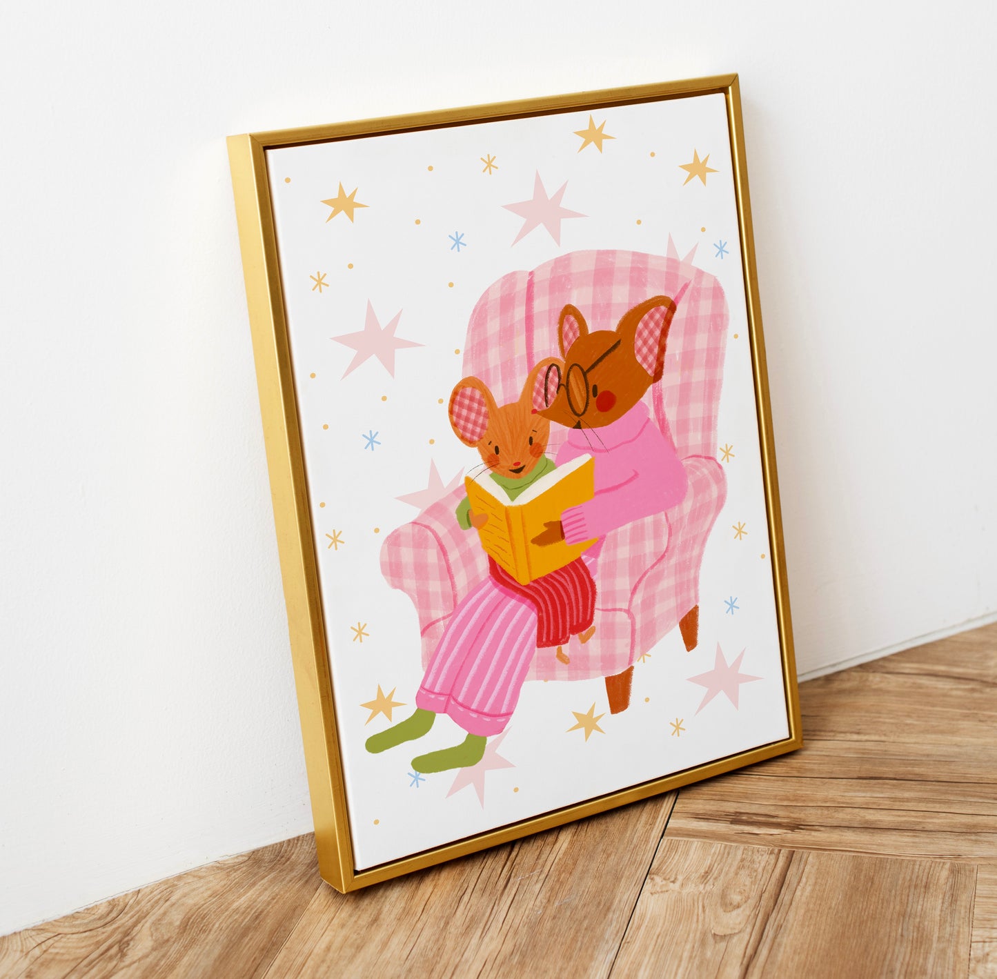 wall art with an illustration of two mice reading a book in a checkered chair with a pink background. Children's book inspired wall decor