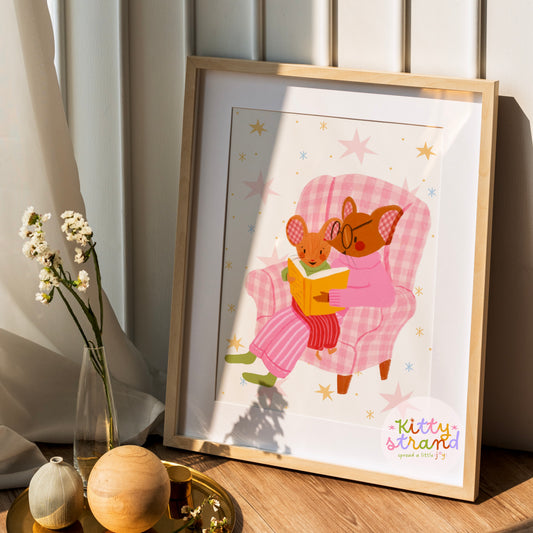 wall art with an illustration of two mice reading a book in a checkered chair with a pink background. Children's book inspired wall decor