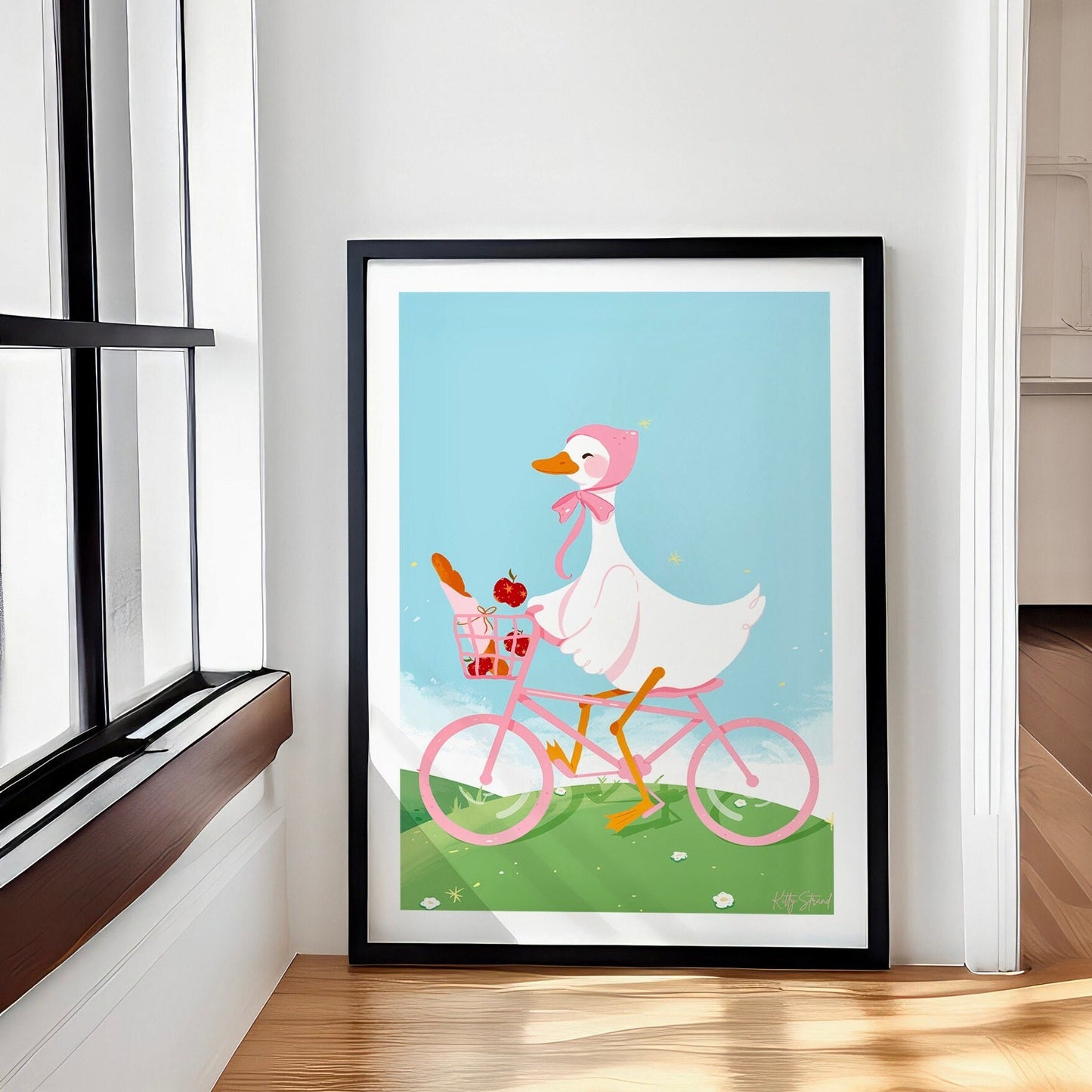 Framed artwork of a cartoon duck riding a pink bicycle with a basket on a blue background.