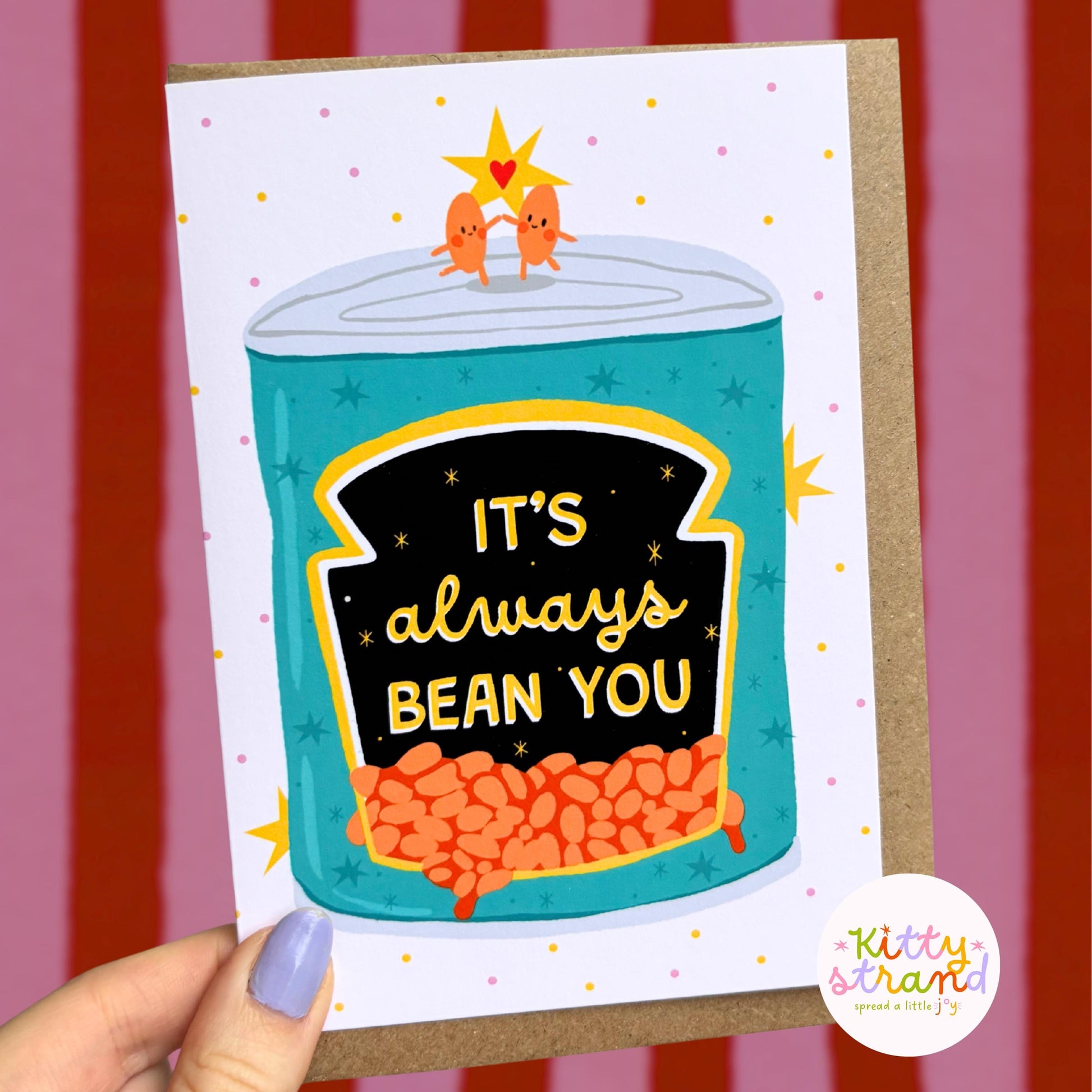 Card with a can of beans illustration and 'It's always bean you' text, held against a striped background.