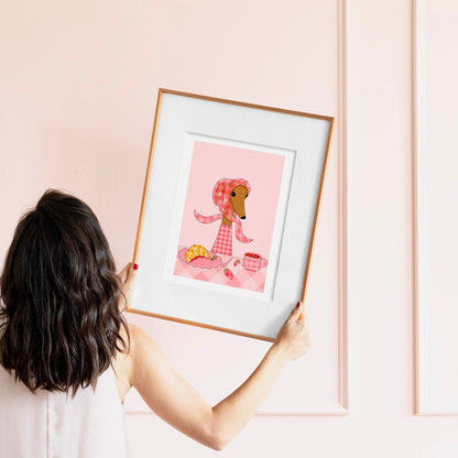 Person holding a framed illustration of a dog eating brunch 