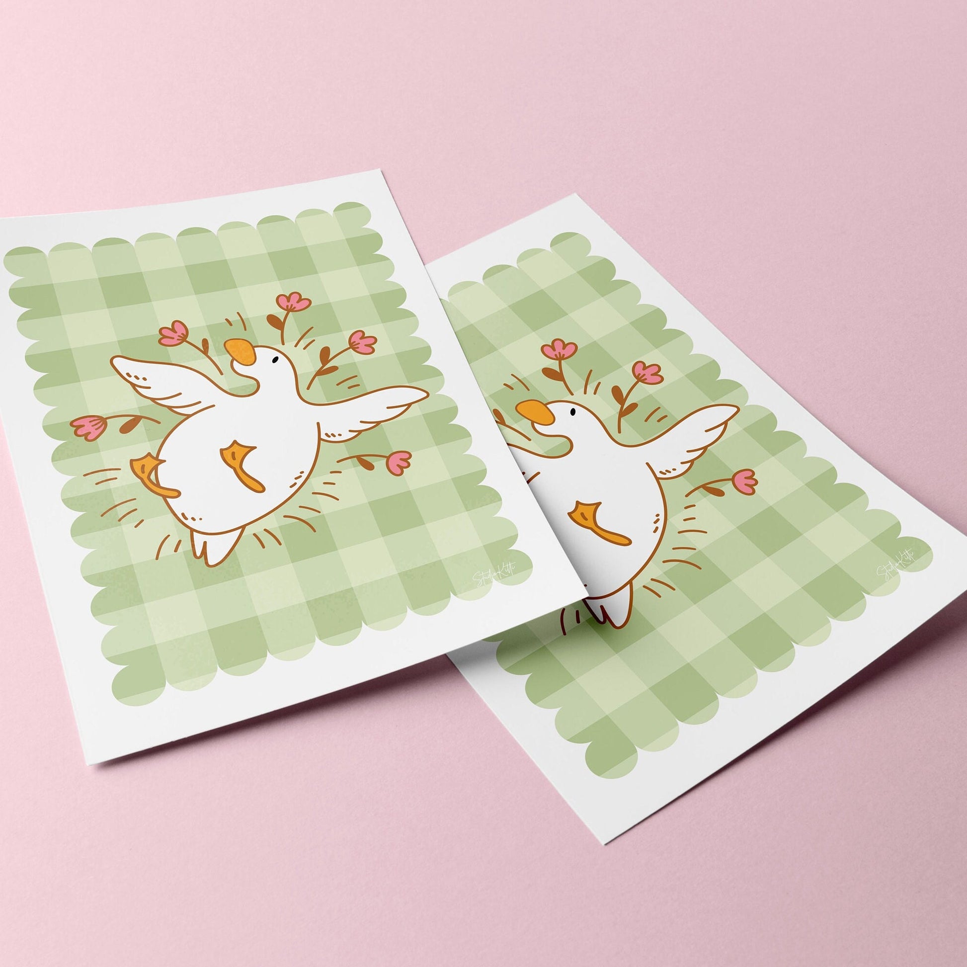 gingham wall art with an illustration of a duck / goose laying surrounded by flowers 