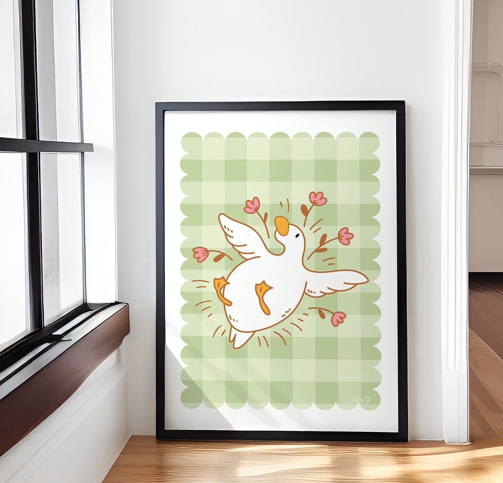 gingham wall art with an illustration of a duck / goose laying surrounded by flowers 