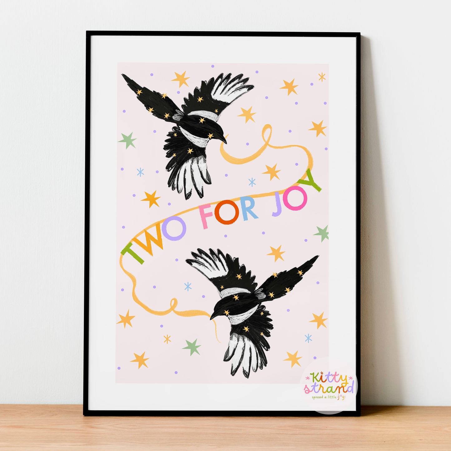 Framed artwork with two magpie illustrations and colorful text on a light background