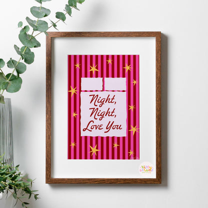 Framed artwork with 'Night, Night, Love You' text on a pink striped background, placed on a white surface with a plant.