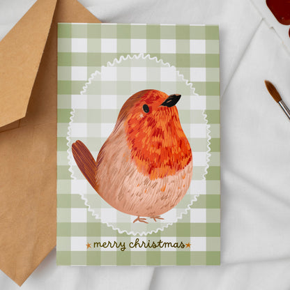 Greeting card with a robin design and 'merry christmas' text against a soft green gingham background 